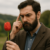 A man holding a tulip, thinking why does human penis has a head.